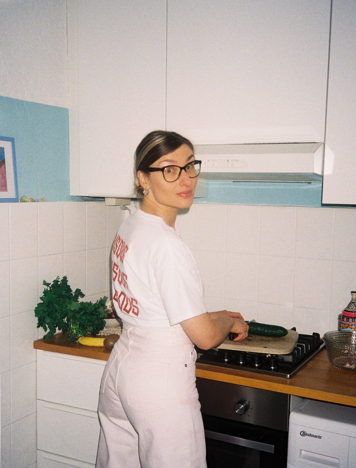 Michelle schneidet frische Gurke und schaut in die Kamera