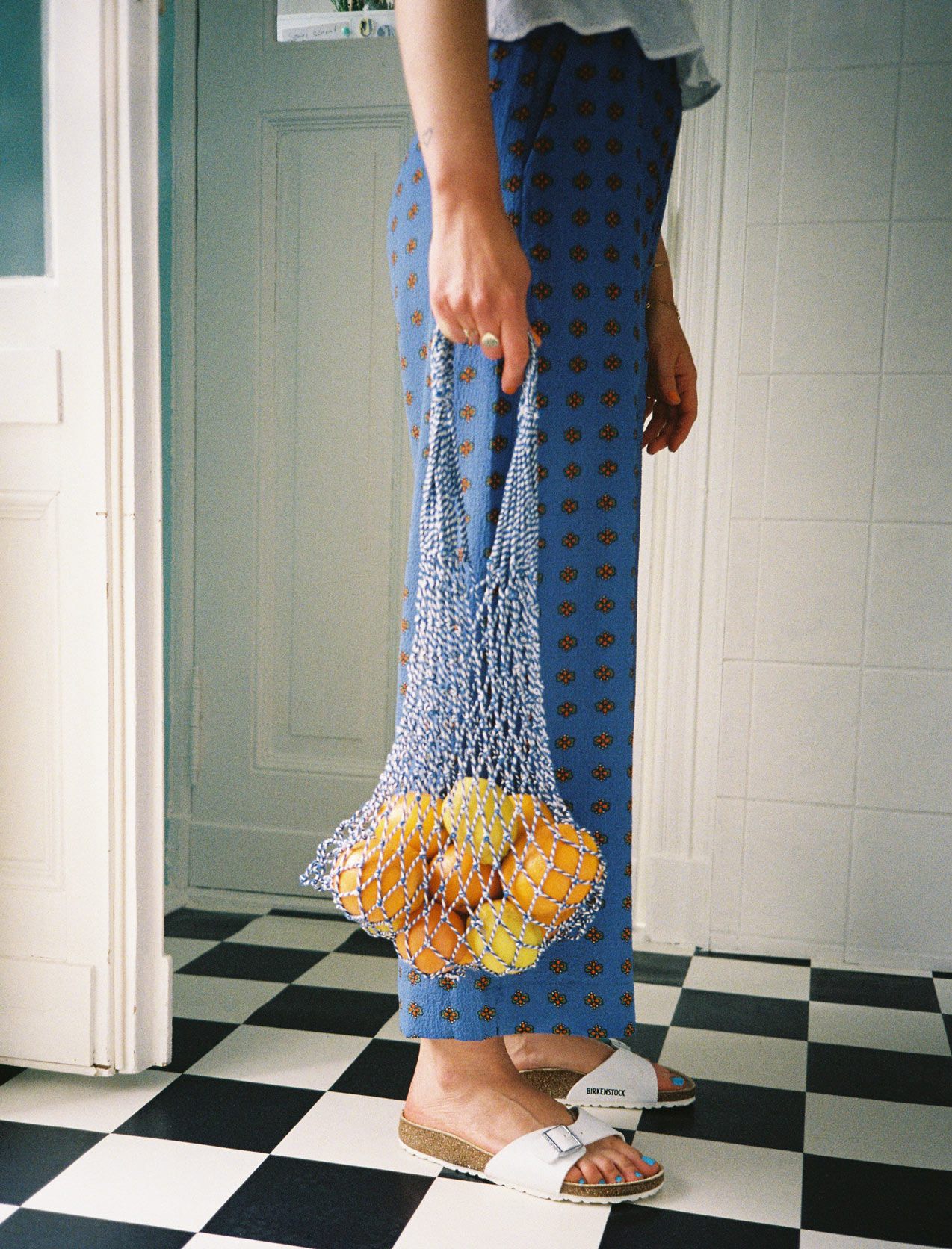 Einkaufsnetz mit frischen Zitrusfrüchten in der Küche